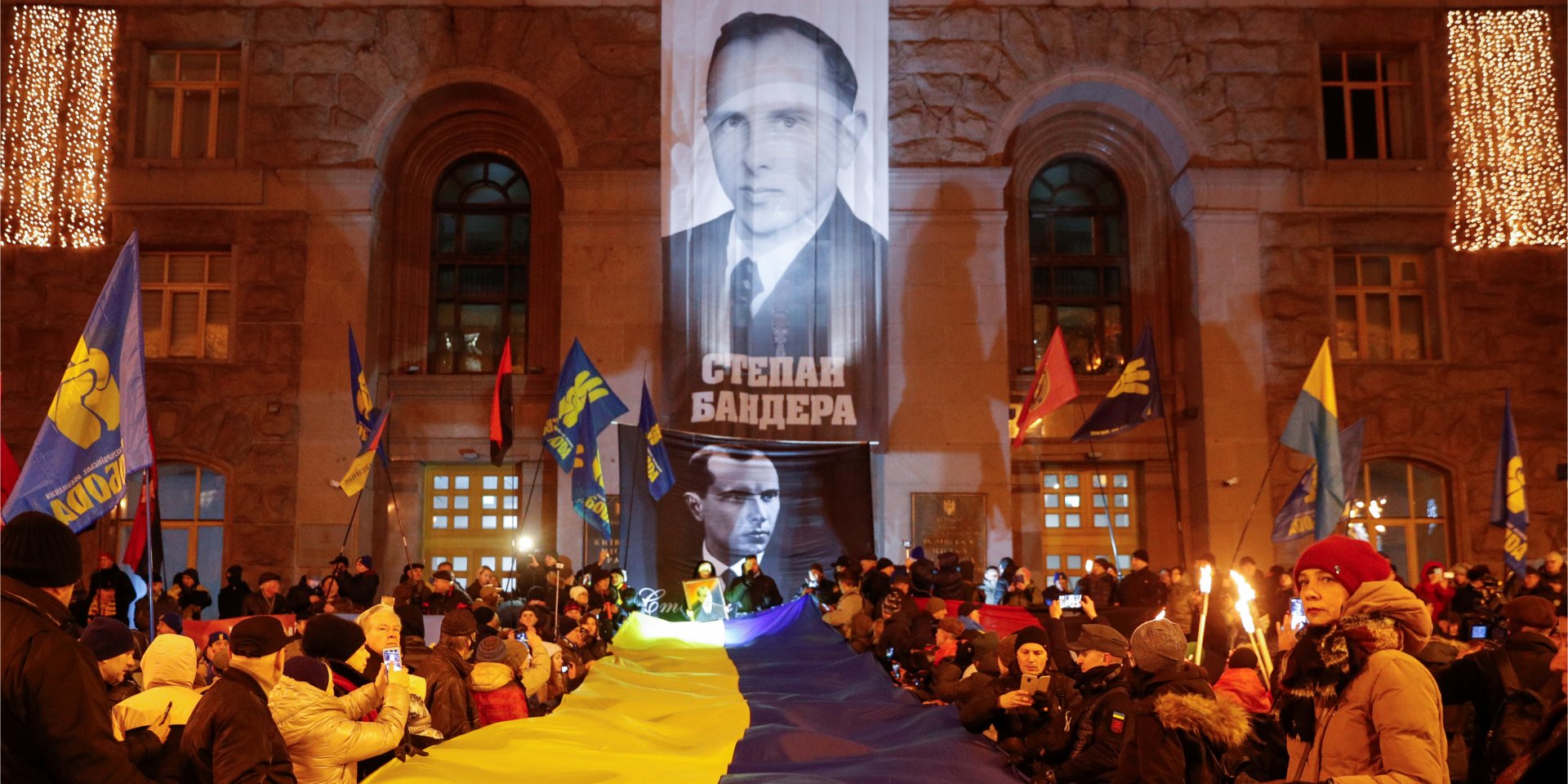Учасники ходи на&nbsp;честь дня народження Степана Бандери розгорнули український прапор перед будівлею КМДА 1 січня (Фото: REUTERS / Valentyn Ogirenko)