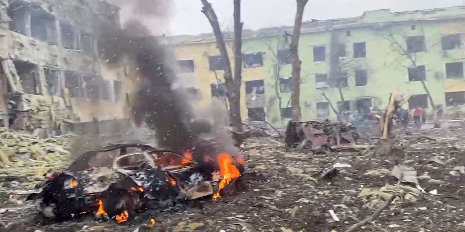 Автомобіль, що&nbsp;горить на&nbsp;тлі дитячої лікарні, яка зазнала авіаудару в&nbsp;Маріуполі, 9 березня (Фото: Ukraine Military / Handout via REUTERS)