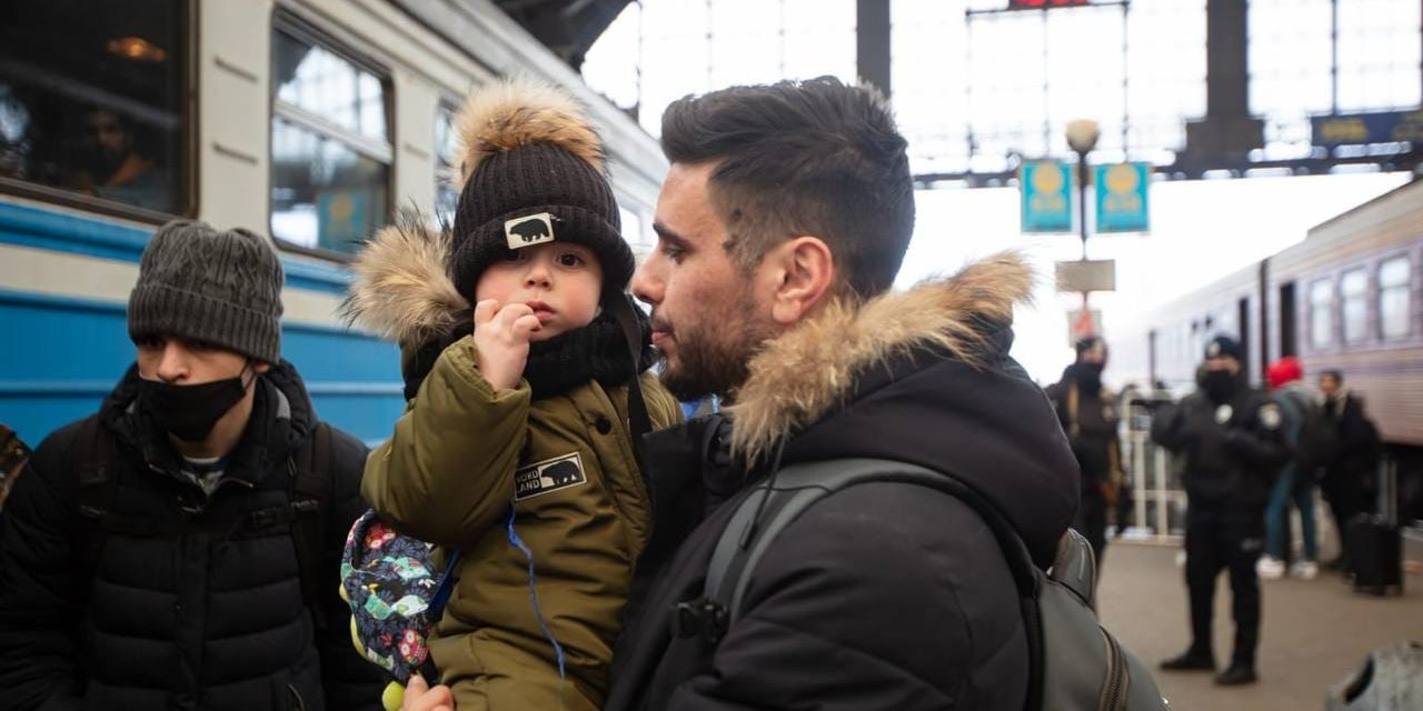A man holds his son during evacuation from Ukraine (illustrative photo) (Photo: Ukrzaliznytsia)