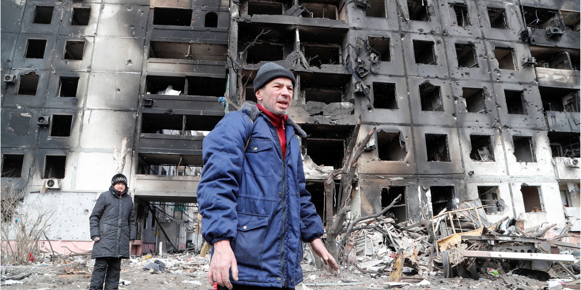 Ukrainians pictured next to a destroyed residential building in Mariupol on March 17 (Photo: REUTERS/Alexander Ermochenko)