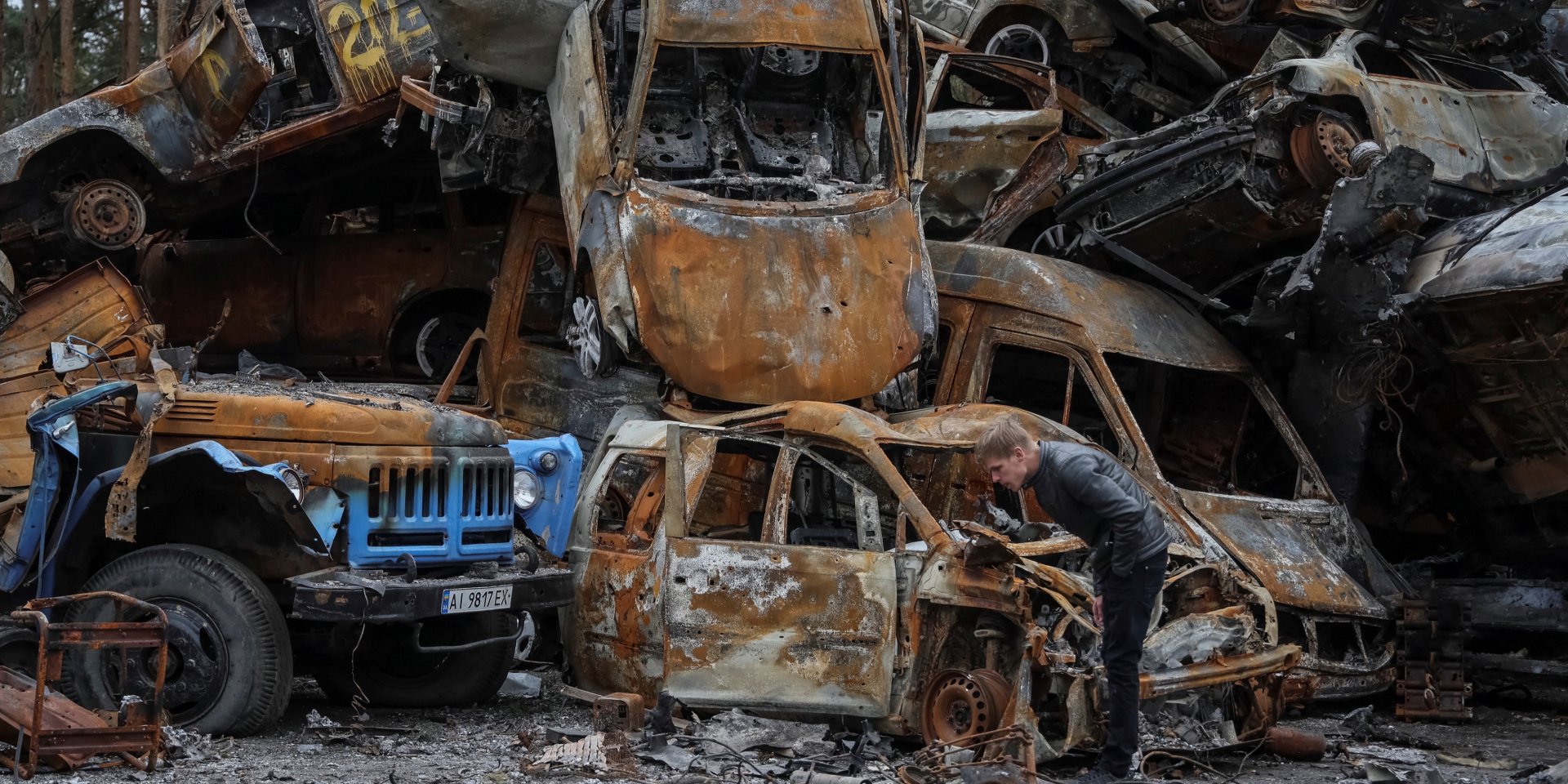 A man stands at a graveyard of cars, destroyed by Russian attacks in Irpin, Kyiv Oblast (Photo: REUTERS/Gleb Garanich)