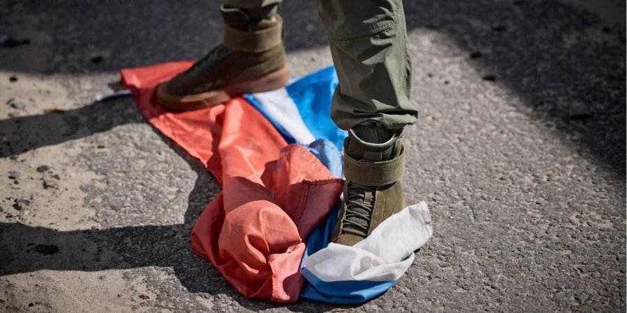 A man tramples the flag of the Russian Federation in Kupyansk, Kharkiv Oblast (Photo: Ukrainian Presidential Press Service/Handout via REUTER)
