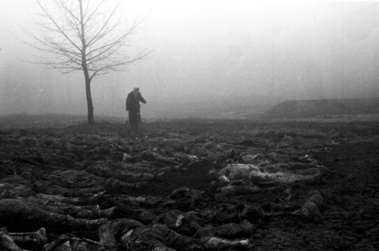 1944, Україна, Київ. Жінка розшукує тіло свого чоловіка серед трупів, які витягли з ям на території Сирецького концентраційного табору. Багатьох в'язнів цього табору розстрілювали в Бабиному Яру (Фото: ЦДКФФА України імені Пшеничного)