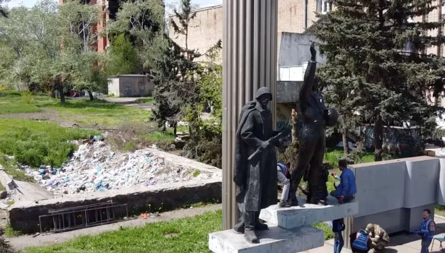 People tidy up a Soviet-era monument in Mariupol (Фото: Petro Andriushchenko)