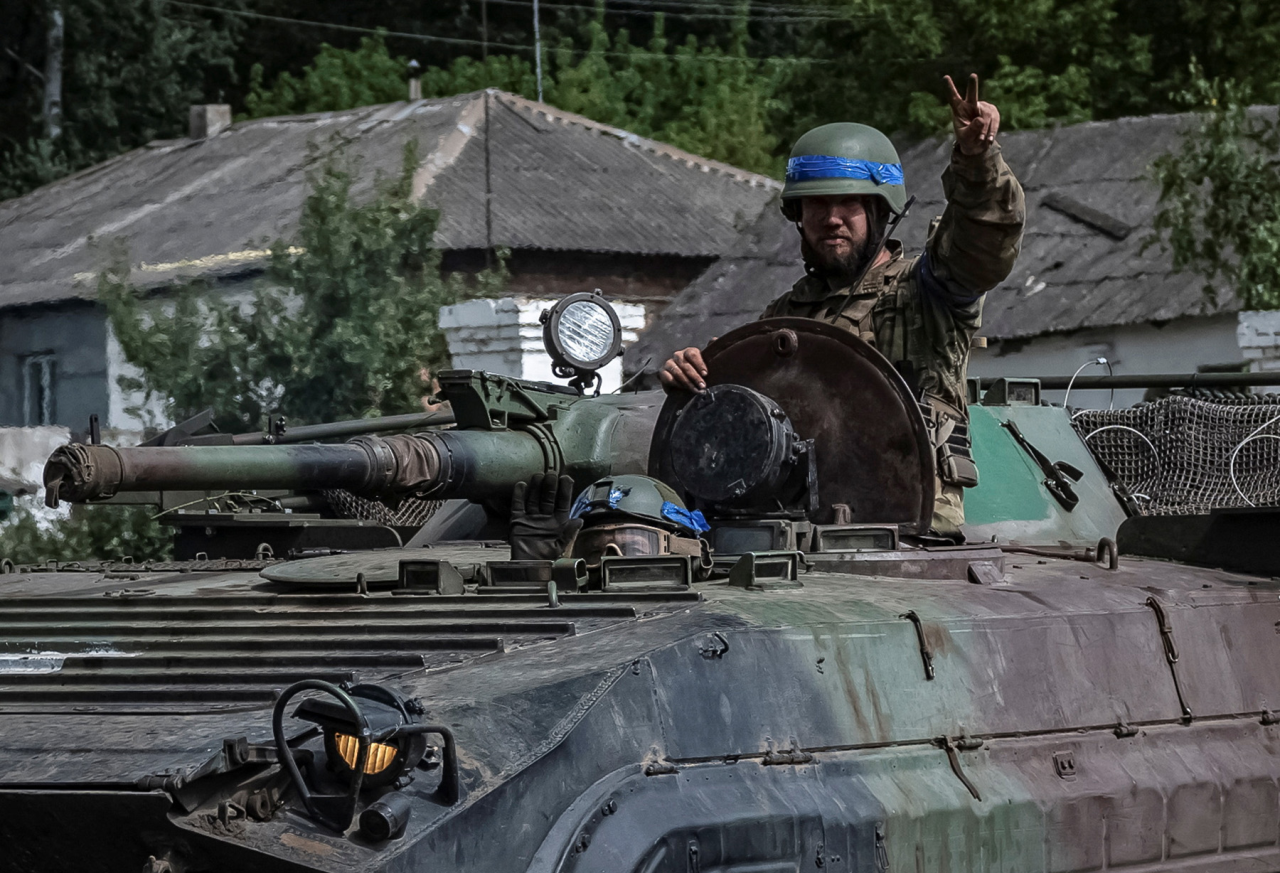 К БОЮ ГОТОВ: Военнослужащий ВСУ приветствует репортеров из боевой машины пехоты в Сумской области недалеко от границы с Россией (Фото: Viacheslav Ratynsky / Reuters)