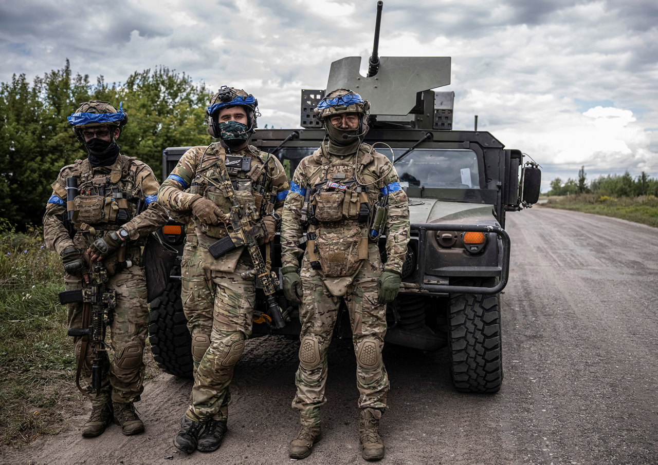 ПО ДОРОГЕ НА СЕВЕР: Украинские бойцы позируют на фоне военной машины в Сумской области недалеко от границы с Россией (Фото: Viacheslav Ratynskyi / Reuters)