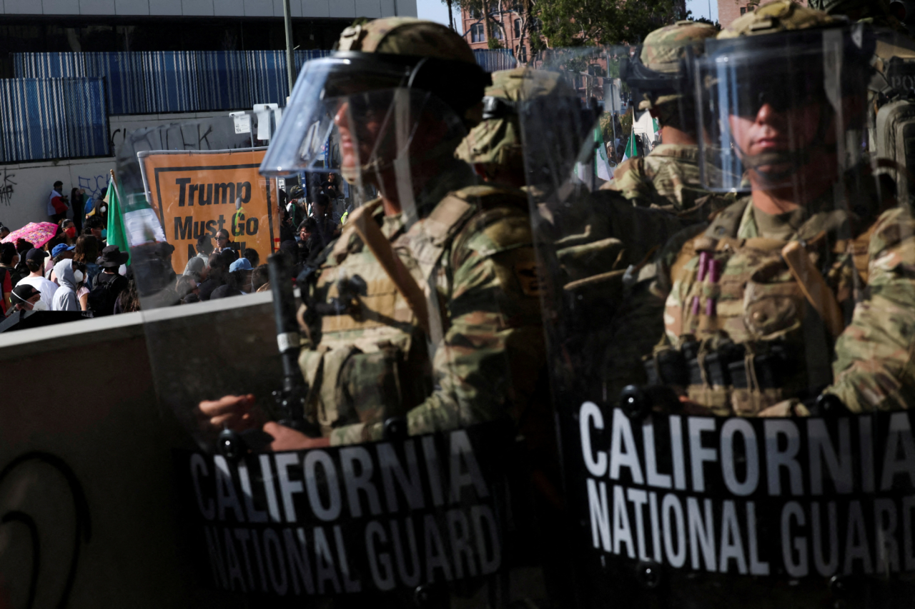 California National Guard members block the entrance to a federal building in downtown Los Angeles amid protests. “Trump must go” reads one of the signs, on June 9, 2025. (Фото: REUTERS/Leah Millis/File Photo)