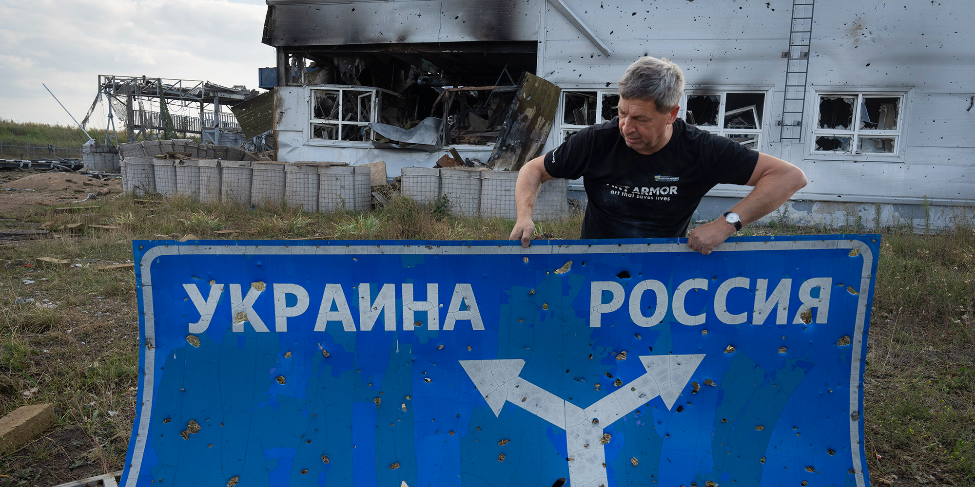 РАЗОШЛИСЬ ДВЕ ДОРОГИ: Директор музея Второй мировой войны Юрий Савчук в Судже держит дорожный знак — ныне экспонат выставки о курском наступлении в Киеве (Фото: Ефрем Лукацкий via AP)